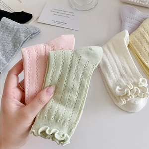 Detailed view of breathable vertical mesh socks with elegant ruffle cuffs in pastel colors