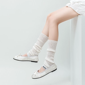 Detail of white Lolita leg warmers paired with satin ballet flats and bow decoration
