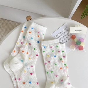 Detail of white mesh crew socks with colorful polka dots and hearts pattern