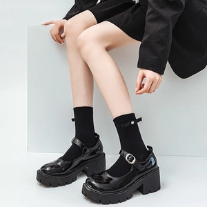 French style black patent leather platform Mary Janes with pearl bow socks on white stand