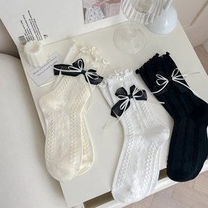 Detail of Lolita style socks with double ribbon bows and ruffled lace edges in three colors