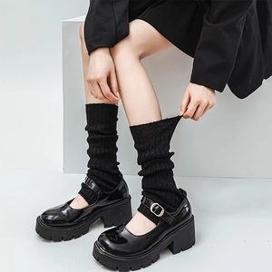 Lolita style black knit leg warmers paired with glossy patent leather Mary Jane shoes