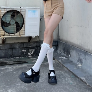 Détail de chaussettes blanches Lolita à dentelle et nœuds avec chaussures Mary Jane