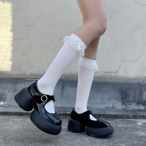 Détail de chaussettes Lolita blanches à dentelle et nœud avec chaussures Mary Jane