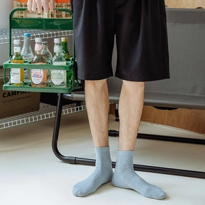 Detail of light blue crew socks featuring ribbed texture in a casual outdoor setting