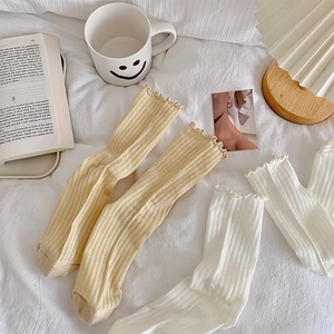 Detail of ruffle trim cotton mesh socks in beige and white with vertical ribbed texture