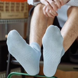 Detail of light blue waffle knit cotton crew socks featuring breathable honeycomb texture