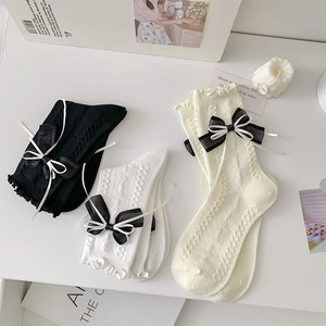 Detail of sweet Lolita mid-calf socks with layered bows and delicate ruffled edges