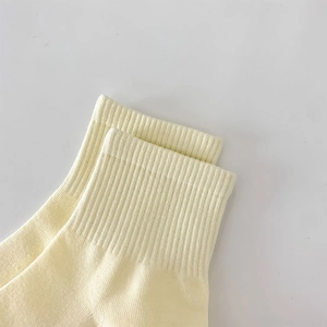 Detailed macro view of the elastic ribbed cuff on light yellow knitted cotton socks