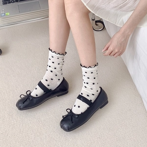 Women's black Mary Jane flats with bow detail paired with white polka dot mesh socks