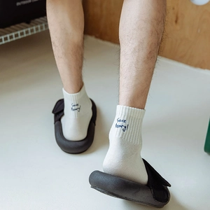 Detail of white cotton crew socks with Save Money embroidery and ribbed texture