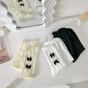 Détail de chaussettes JK torsadées avec dentelle et nœuds en satin noir en trois couleurs