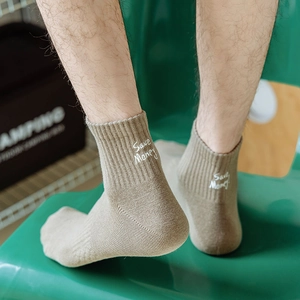 Detail of light brown ribbed socks with white 'Save Money' embroidery on the ankle cuff