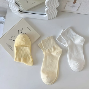Detail of cream and white ribbed cotton socks paired with minimalist lifestyle decor