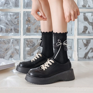 Detail of black platform loafers with dual-layered bow knit crew socks for JK style