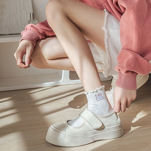 Gros plan de chaussettes blanches à volants avec broderie lapin et chaussures Mary Jane