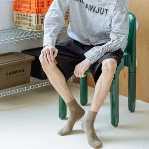 Close-up of khaki crew sock featuring classic ribbed texture on model's feet