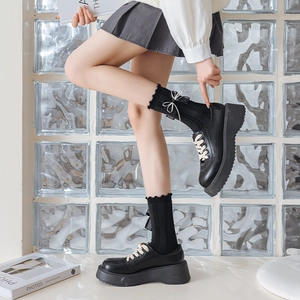Close-up of black platform loafers with lace bow socks in Japanese school style