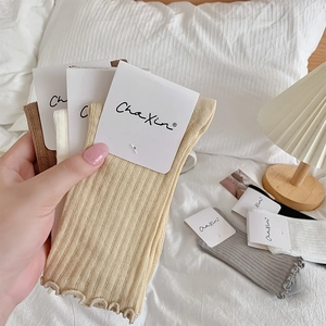 Detailed texture of ruffled hem cotton mesh socks in various neutral earth tones