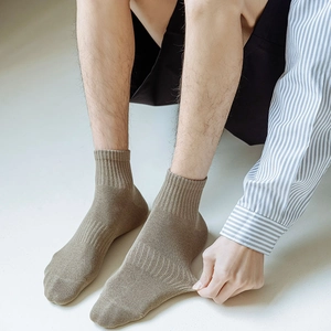 Close-up of khaki ribbed cotton crew socks with high elasticity on a model