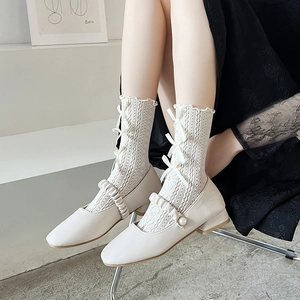 Detail der weißen hohlen Spitzen-Socken mit Schleife und Mary Jane Schuhen im Lolita-Stil