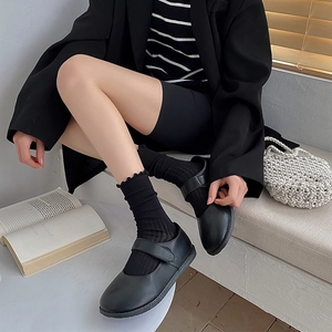 Detail of black frilly mesh socks paired with vintage Mary Jane shoes in a lifestyle setting
