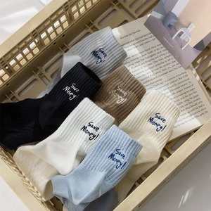 Detail of multi-color cotton crew socks with Save Money! embroidery in a storage basket
