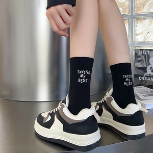 Close-up of crew socks with white letter embroidery and striped texture in casual style