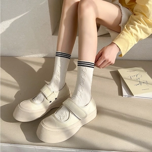 Close-up of white JK style crew socks with textured knit and black stripes on the cuffs