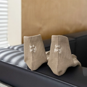 Detail of khaki ribbed knit socks with 'Save Money!' embroidery on the heel area