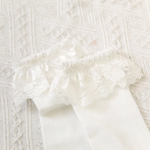 Detail of white knee-high socks with delicate double-layered lace floral trim edges
