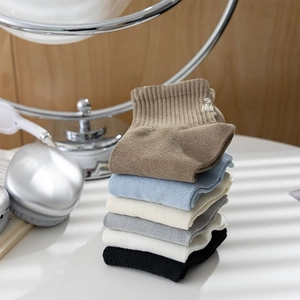 Detailed view of ribbed cotton crew socks with minimalist 'S' embroidery on the cuff