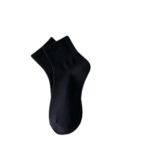 Classic black low-cut cotton socks with elastic ribbed cuffs on plain white background
