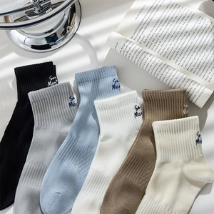 Detailed view of 6 pairs of colorful crew socks with San Mon embroidery on rib cuffs
