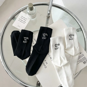 Detail of ribbed mid-calf socks featuring TRYING MY BEST embroidery on cotton fabric