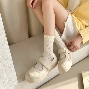 White platform Mary Jane shoes with textured mid-calf socks on stone steps