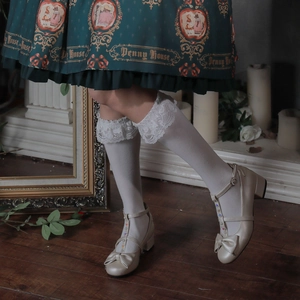Close-up of beige Lolita platform shoes with bow and crystal accents on lace socks