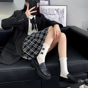 Détail de chaussettes blanches style JK avec nœuds noirs et mocassins à plateforme