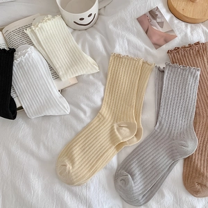 Detail of ruffle cuff socks with vertical ribbed texture in various pastel colors