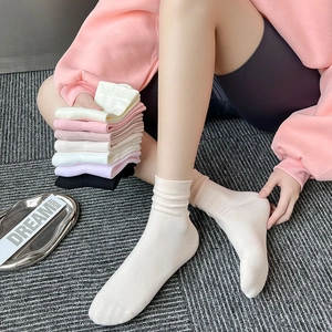 Detail of ribbed cotton mid-calf socks in various Morandi colors shown on model