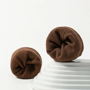 Close-up of brown knit two-toe socks showing detailed vertical ribbed texture on white stand
