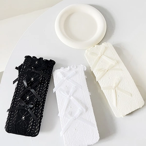 Details der Spitzentextur und Satinschleifen an japanischen Lolita-Kniestrümpfen