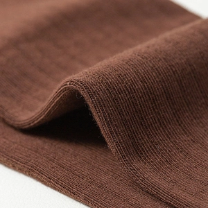 Macro detail of dark brown ribbed knit fabric showing elastic texture on two-toe socks