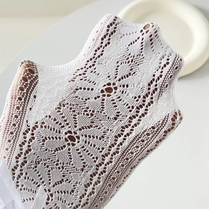 Nahaufnahme weißer Spitzen-Socken mit Schleife und filigranem Jacquard-Hohllochmuster