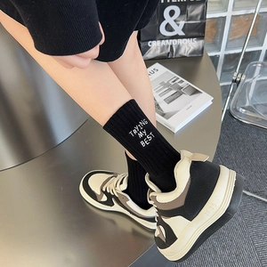 Women's ribbed cotton mid-calf socks with white embroidery paired with chunky retro sneakers