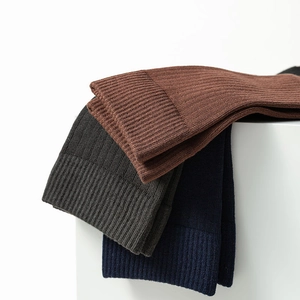 Detail of ribbed knit cuffs on men's two-toe socks in brown, grey, and navy colors