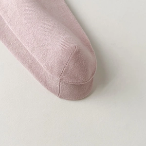 Detail shot of light pink cotton knit socks showing seamless toe and soft texture
