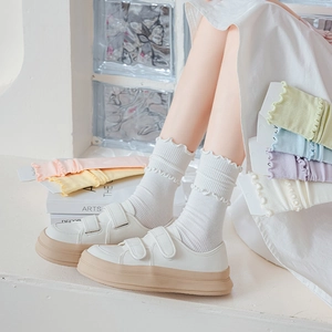 Detail of ruffled knit socks in macaron colors paired with white platform sneakers