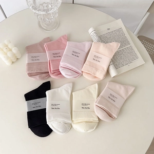 Close-up of eight pairs of ribbed cotton mid-calf socks in various soft pastel colors