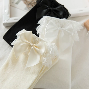 Détails des bordures en dentelle et nœuds en satin sur des chaussettes hautes style Lolita